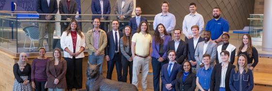 YAPCO members posing with Scratch, wildcat mascot statue.